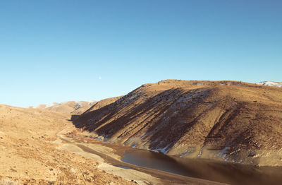 Scenic view of sand dunes against clear sky