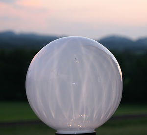 Close-up of illuminated crystal ball against sky during sunset