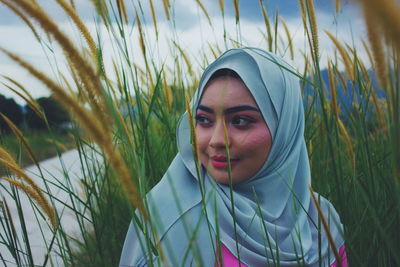 Portrait of young woman against plants