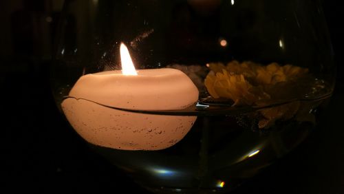 Close-up of burning candle on table