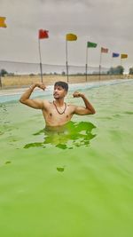 Full length of shirtless man in swimming pool