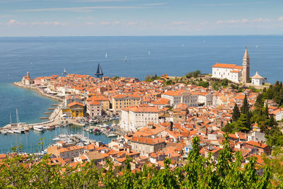 High angle view of townscape by sea against sky