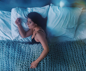 High angle view of woman lying on bed