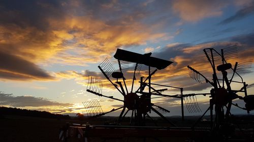 Low angle view of silhouette traditional windmill against sky during sunset