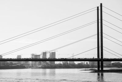 Suspension bridge over river against sky