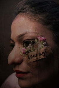 Close-up portrait of woman with pink flowers