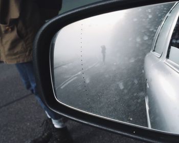 Low section of man on side-view mirror