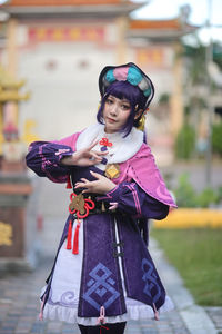 Portrait of smiling young woman standing in city