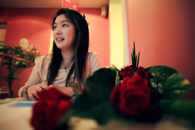 Portrait of young woman with red roses