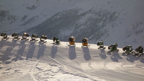 Machinery on snowy field against mountains