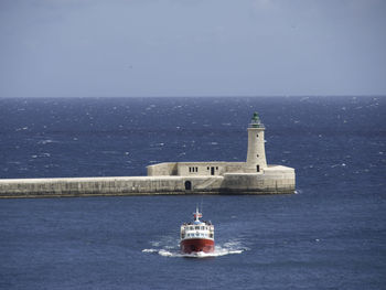 Scenic view of lighthouse by sea against sky