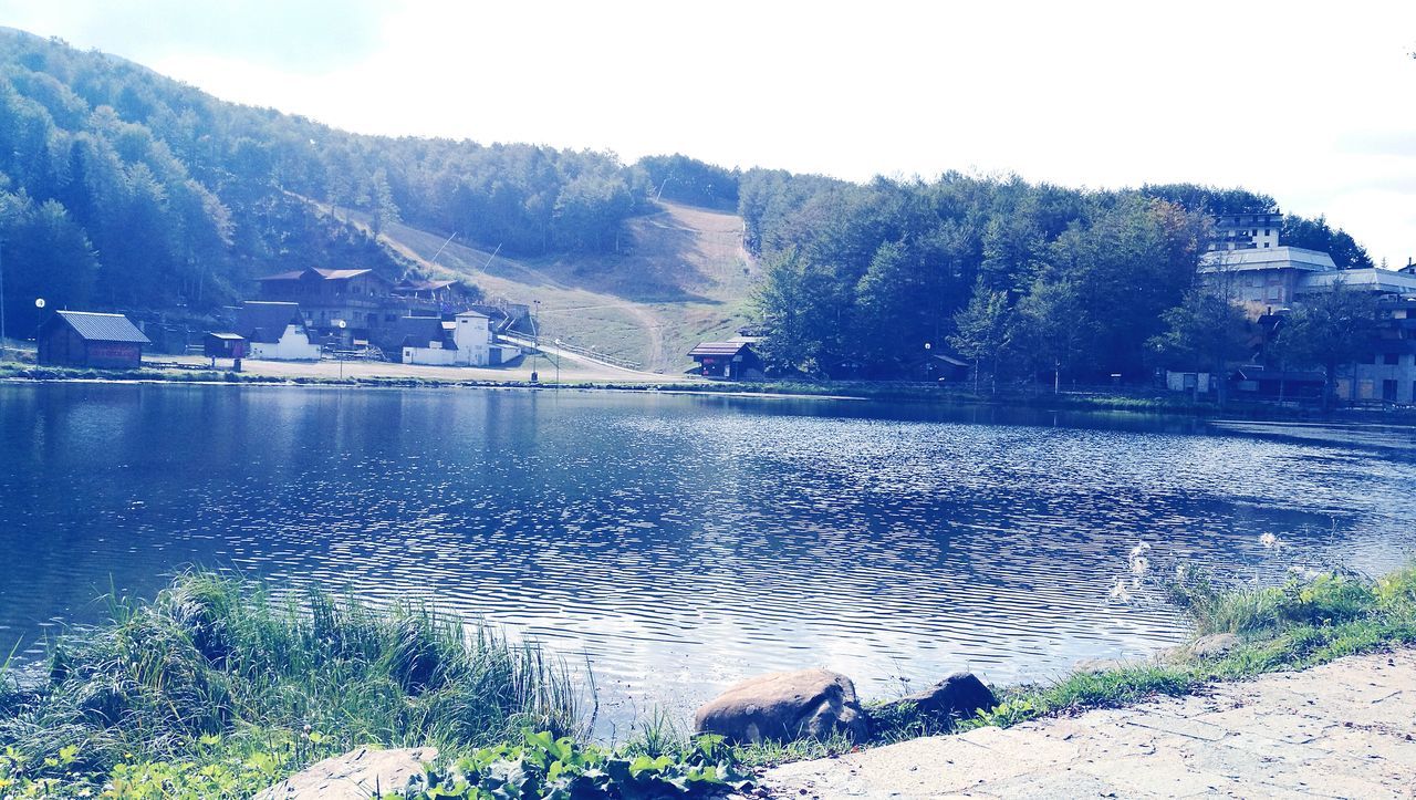 water, tranquil scene, tranquility, scenics, mountain, lake, beauty in nature, nature, non-urban scene, reflection, calm, remote, day, sky, outdoors, majestic, mountain range, no people, riverbank, town, physical geography, solitude