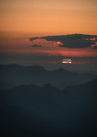 Scenic view of silhouette mountains against romantic sky at sunset