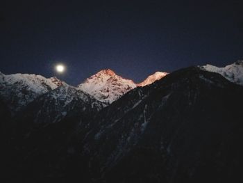 Scenic view of snowcapped mountains against sky at night