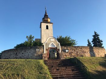 View of bell tower against blue sky in balatonalmádi - national heritige church