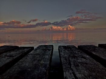 Pier over sea against sky during sunset