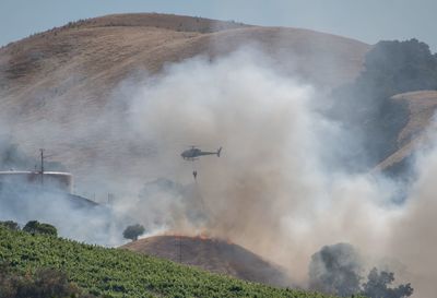 High angle view of helicopter flying over mountains