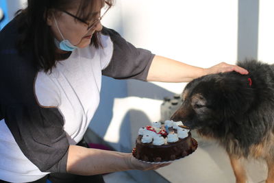 Side view of woman with birthday dog and birthday cake