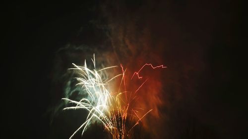 Low angle view of fireworks against sky at night