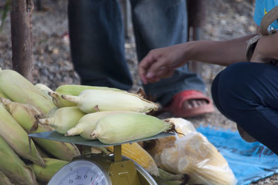 Midsection of person crouching by weight scale with corns