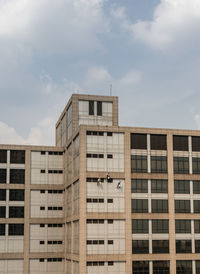 Low angle view of building against cloudy sky