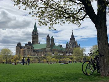 People on park by building against sky