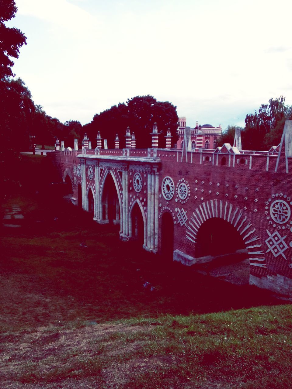 architecture, built structure, connection, arch, bridge - man made structure, tree, sky, transportation, graffiti, arch bridge, bridge, outdoors, text, road, day, travel destinations, engineering, incidental people, the way forward, building exterior