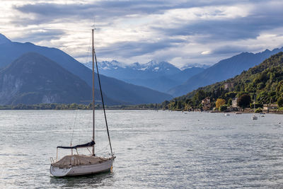 Sailboat in sea against mountains