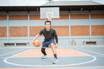 Portrait of man playing with basketball