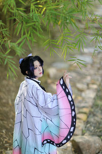 Side view of woman standing against plants