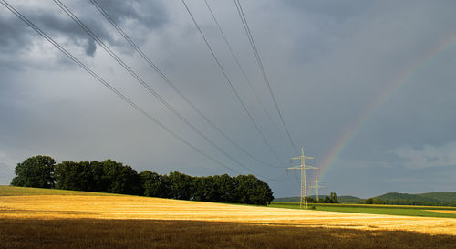Electricity pylon on field against sky