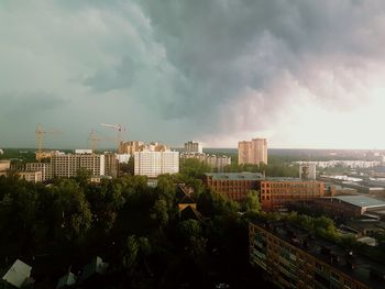 View of cityscape against cloudy sky