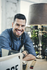 Portrait of happy cashier at table