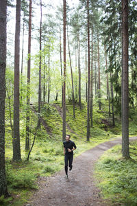 Mid adult man running through forest