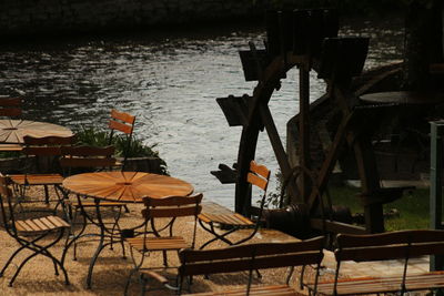 Empty chairs and tables at restaurant by sea