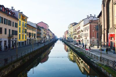 Canal amidst city against clear sky