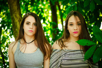 Portrait of young female friends against trees