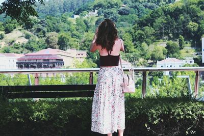 Woman standing on tree trunk