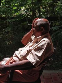 Side view of a man sitting outdoors
