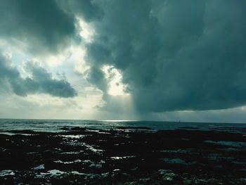 Scenic view of sea against storm clouds