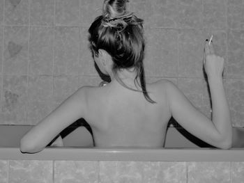 Rear view of young woman in bathroom