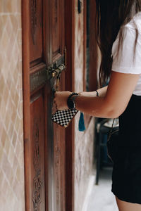 Rear view of woman standing by door