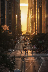 Traffic on city street and buildings at sunset