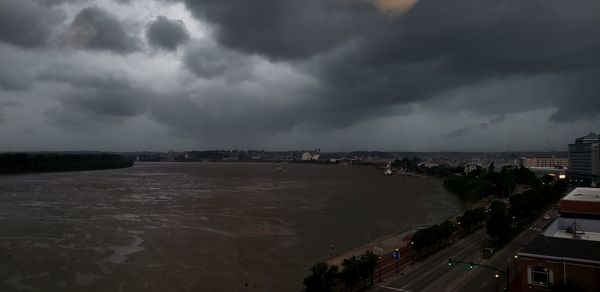 High angle view of city by sea against sky