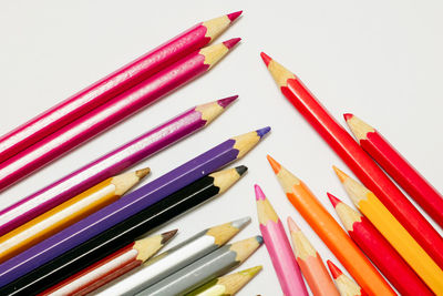High angle view of colored pencils against white background