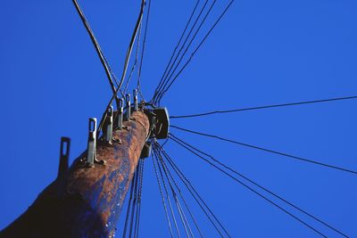 Low angle view of cables against clear blue sky