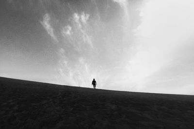 Man standing on field against sky