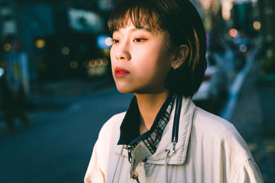 Portrait of woman looking away in city