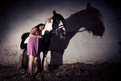 Young woman standing with shadow on the ground