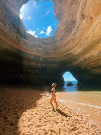 Rear view of woman standing at beach